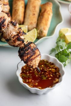 the skewers are being served with dipping sauce