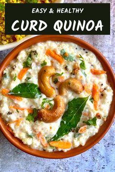 a bowl filled with rice, carrots and cashews on top of a table