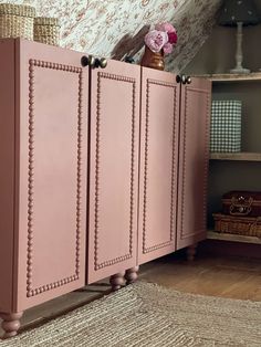 a pink cabinet sitting on top of a wooden floor