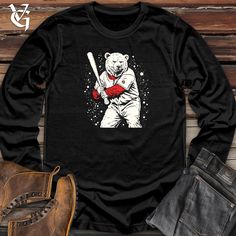 a bear holding a baseball bat on top of a wooden floor next to a pair of jeans