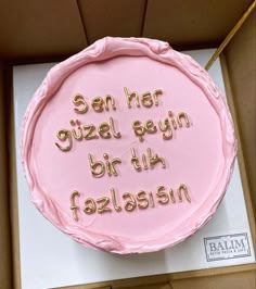 a pink birthday cake in a box that says, sein rier gizzal gegin bih fazlasion