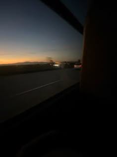 the sun is setting on the horizon as seen from inside a vehicle's window