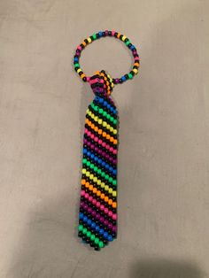 a multicolored beaded tie is hanging on a keychain