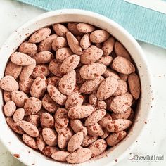 a white bowl filled with chocolate chips on top of a blue table cloth next to a napkin