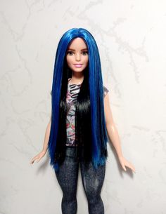 a doll with blue hair and black pants