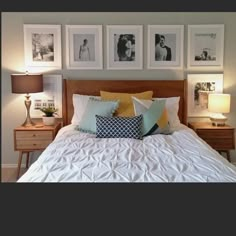 a bed with pillows and pictures on the wall above it