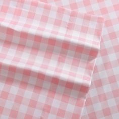 the pink and white checkered shirt is folded on top of another piece of cloth