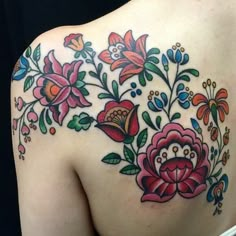 the back of a woman's shoulder with flowers on it