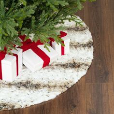 three presents wrapped in red and white are sitting on a rug next to a christmas tree