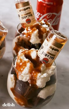 two glasses filled with ice cream, caramel and whipped cream on top of each other