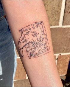 a person with a tattoo on their arm that has an image of a window in it