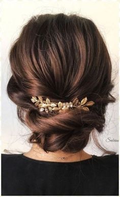 a woman wearing a gold hair comb with leaves on it's side and her hair in a low bun