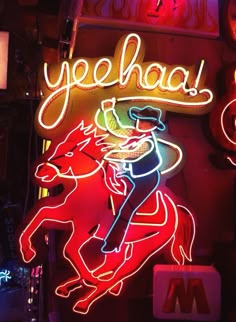 a neon sign that says yeehaa with a cowboy riding a horse on it