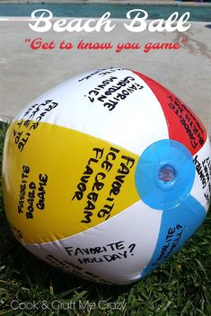 a beach ball sitting in the grass with words written on it