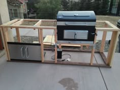 an outdoor grill built into the side of a house with wood framing around it and two ovens on each side