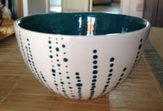 a white and green bowl sitting on top of a counter