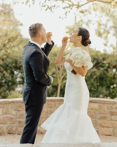 a bride and groom feeding each other cake