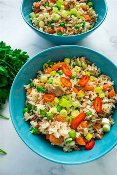 two blue bowls filled with rice and vegetables