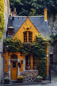 a yellow house with ivy growing on it's side