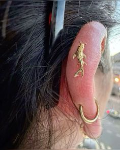 a close up of a persons ear with a lizard on it