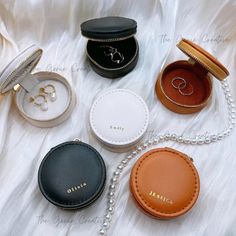 four different types of jewelry sitting on top of a white cloth covered bed next to each other