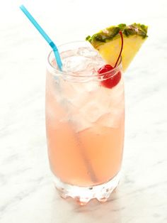 a pineapple drink with a blue straw garnish and a cherry on the rim