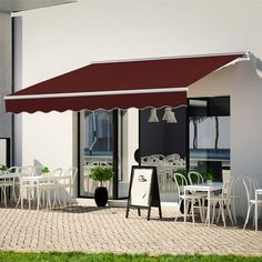 an outdoor restaurant with tables and chairs under a red awning