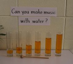 a sign that says can you make music with water? in front of five glasses