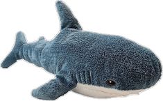 a stuffed shark is laying down on the ground