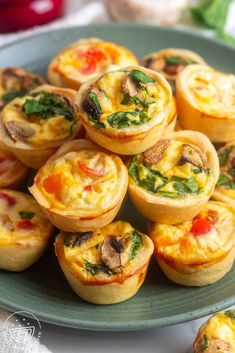 several mini quiches on a plate with spinach and cheese in the middle, ready to be eaten