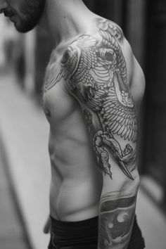 Man with detailed bird tattoo on his shoulder and arm.