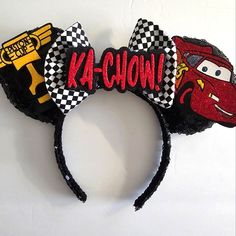 a mickey mouse ears headband that says ka - chow and has cars on it