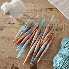 several skeins of crochet needles on a wooden table next to yarn