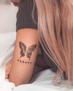 a woman's arm with a butterfly tattoo on the left side of her arm