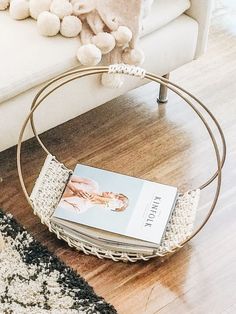 a book is sitting on the floor next to a chair with a teddy bear in it