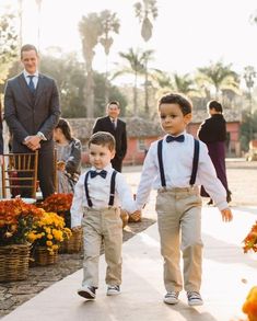 two young boys are walking down the aisle