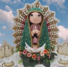 a crocheted doll sitting on top of a cake