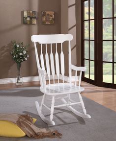 a white rocking chair sitting on top of a rug