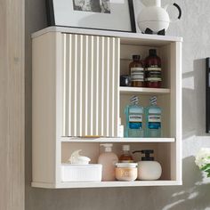 a white cabinet with some bottles and soaps on the top shelf next to it