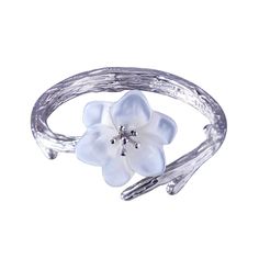 a white flower on a silver bracelet