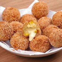 a white bowl filled with fried food on top of a wooden table