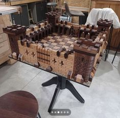 a large wooden model of a castle made out of bricks on a table in a kitchen