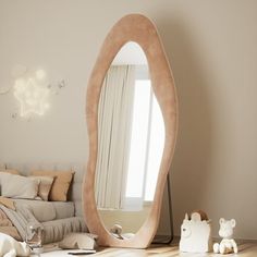 a mirror sitting on top of a wooden table next to a stuffed animal and teddy bear