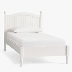 a white bed with two pillows on top of it's headboard and foot board