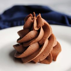 a white plate topped with chocolate frosting on top of a blue cloth covered table