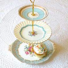 three plates stacked on top of each other with cupcakes and saucers in them