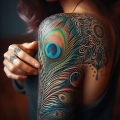 a woman's arm with a peacock tattoo on it and a blue eye in the center