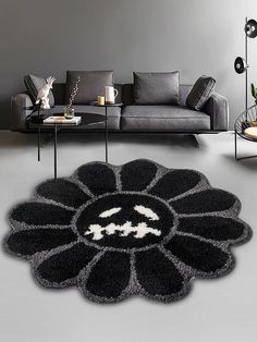 a living room with a black and white rug on the floor next to a couch