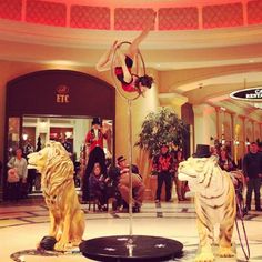 two white tiger statues in the middle of a lobby with people standing around and looking at them