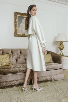 This cozy wool coat will keep you on trend all winter long. The Madeline coat features shoulder pads and a front tie belt to create an hour-glass shape.  The cropped,  flowy back and collared sleeves soften the look and make this coat perfect for a cold winter day. Madeline White, Nana Jacqueline, Simple White Dress, Bride Dress Simple, Cream Coat, Hour Glass, Dress Simple, Gathered Sleeves, White Coat